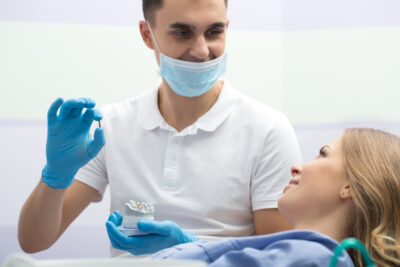 dentist showing patient dental implant