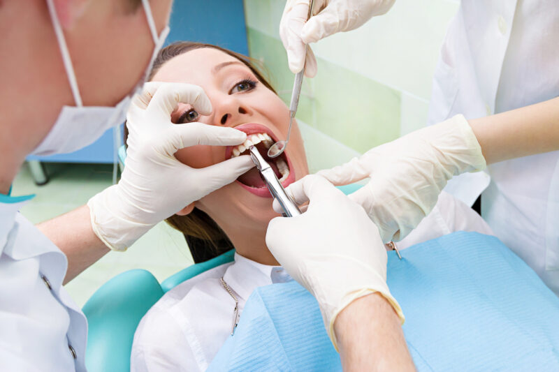 surgical dental extraction procedure - patient in dentist's chair