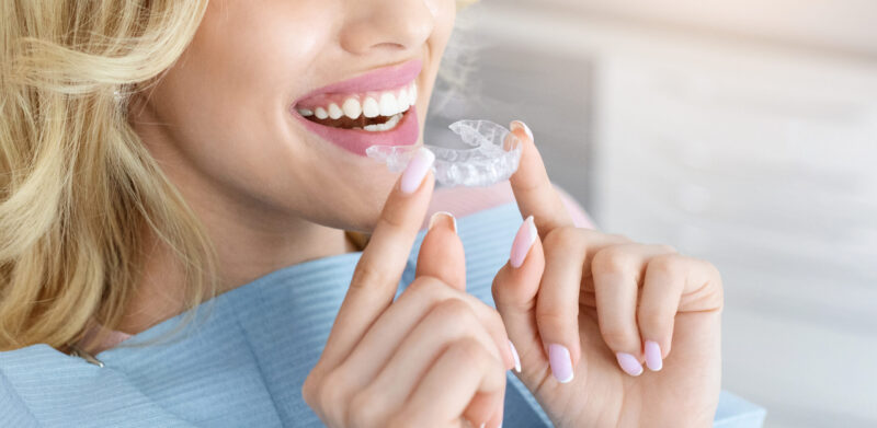 woman with Invisalign clear aligners for straight teeth